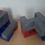L-blokken ingezaagd 2 van in totaal 8 L-vormige blokken, allemaal ingezaagd en voorzien van rode en blauwe accenten. Doordat de blokken verschillen in de wijze van inzagen en in de wijze waarop met rood en blauw deelvolumes gecreëerd zijn zijn er eindeloos veel mogelijkheden voor het combineren van blokken in collages.
Blokgrootte 15x15x15 cm, Belgisch hardsteen.